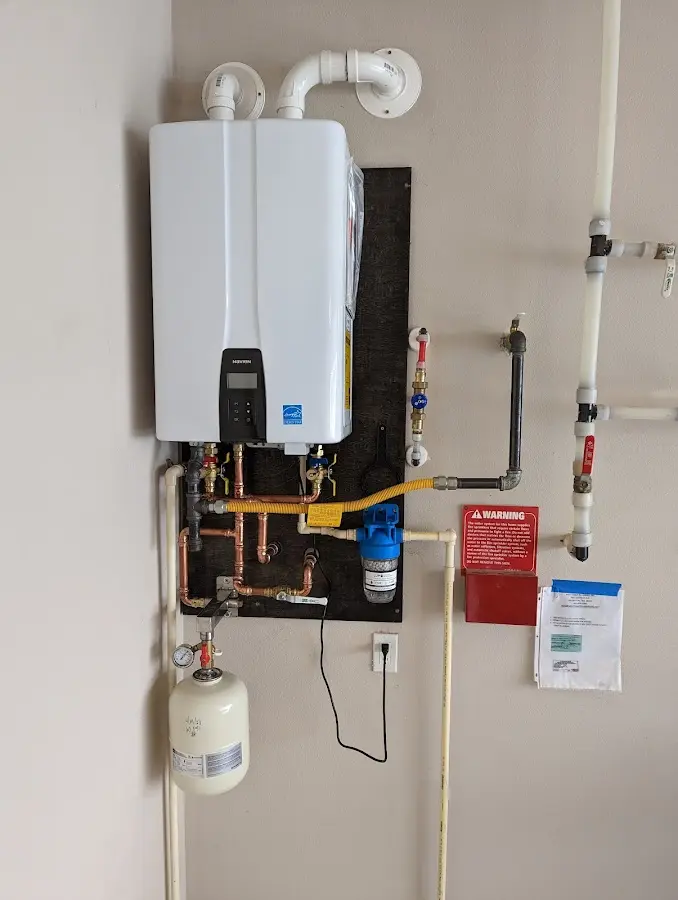 Professional plumber installing copper piping in a Tipp City home